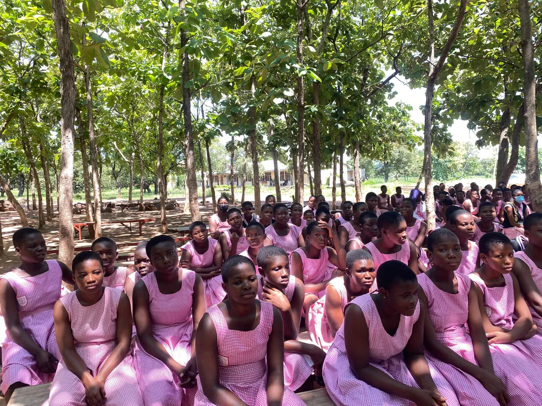 Schoolgirls seated outdoors listening to an MEI session