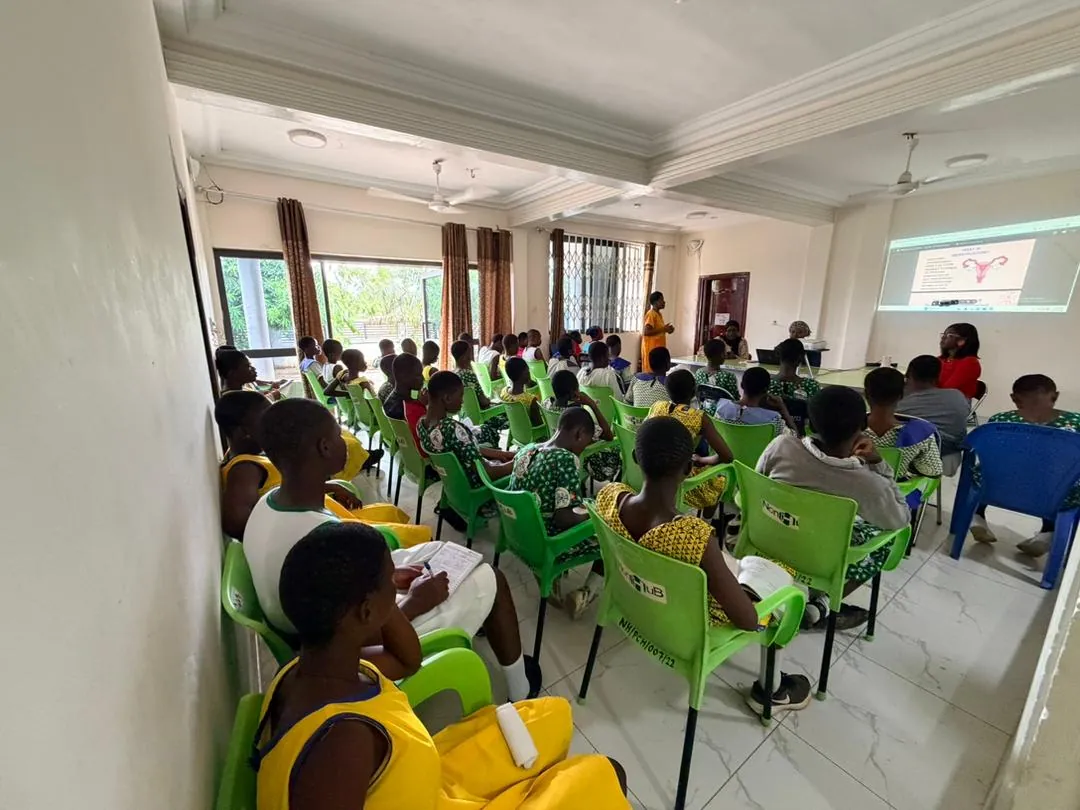 Students in a classroom during a menstrual health presentation