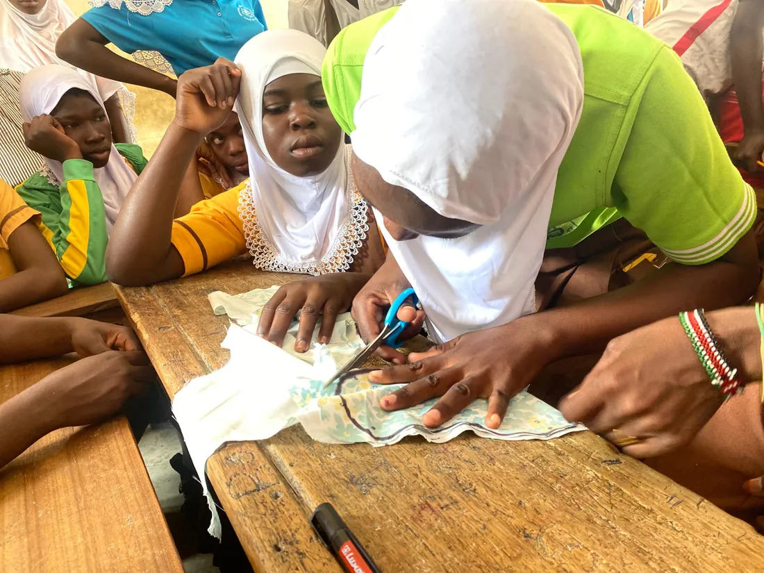 A girl cutting fabric for a reusable pad